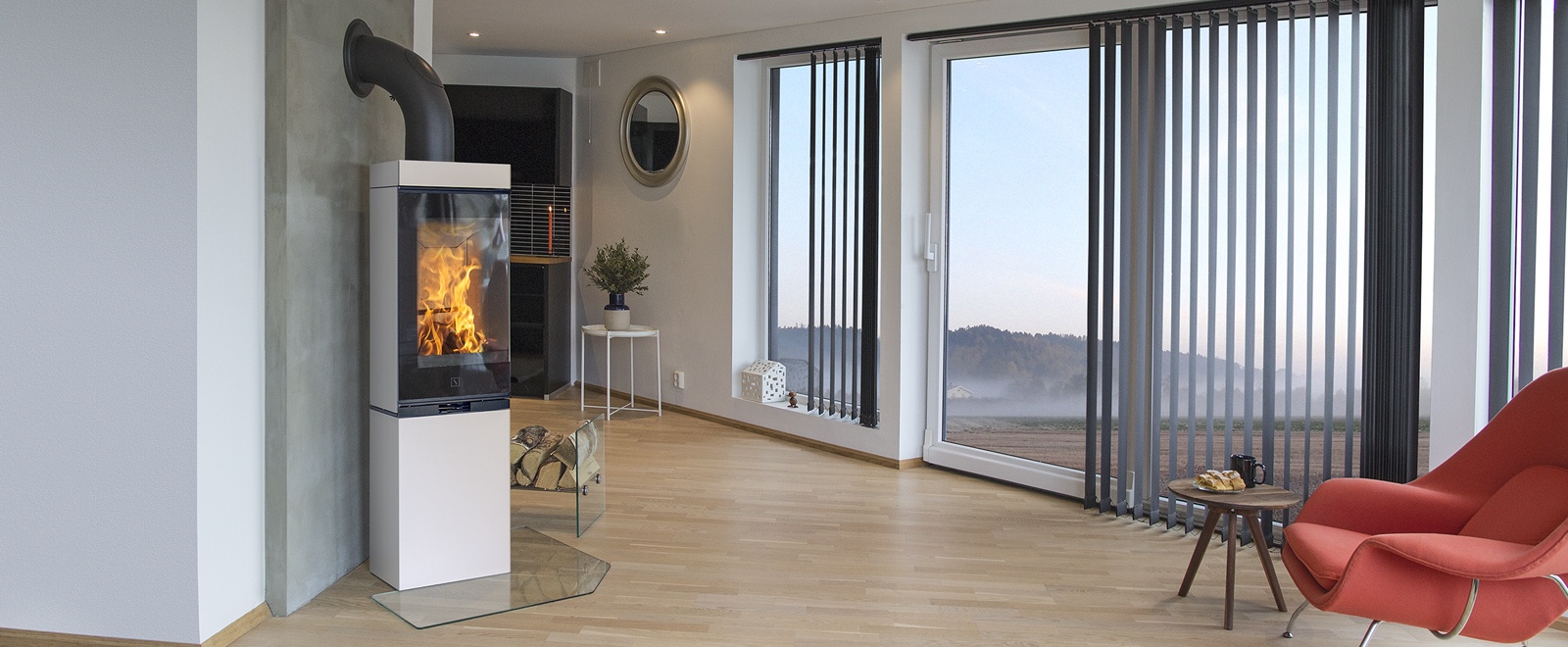 Scan 80 hvit peisovn med panorama innsyn til bålet gjennom 90 graders bøyd glass og panorama innsyn til flammene. Vist i moderne interiør